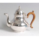 An Edwardian silver bachelors coffee pot, having a finial topped domed hinged cover, walnut handle