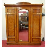 A late Victorian oak, walnut, and burr walnut triple section wardrobe, having a centre arched