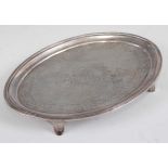 A George III silver teapot stand, of oval form, having a bright cut engraved border of leaves and