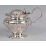 A late Victorian silver mustard pot, of bellied circular form, with domed hinged cover and shell