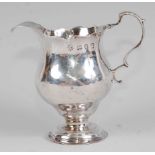 *An early George III silver pedestal cream jug, of helmet form, having serrated edge, 2.2oz,