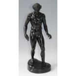 A circa 1900 bronze of a male nude, in standing pose with mallet in his right hand and sword at
