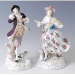 A pair of late 19th century porcelain shepherd and shepherdess figures, each in 18th century