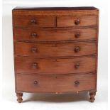 An early 19th century mahogany and satinwood strung bowfront chest, having a crossbanded top over