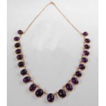 A yellow metal and amethyst fringe necklet, featuring twenty-one graduated oval cabochon cut