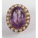 A 9ct yellow gold, amethyst and seed pearl oval cluster brooch, comprising a centre oval faceted