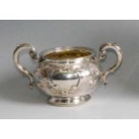 A Victorian silver twin handled sugar bowl, of squat circular form, the body chased with leaves