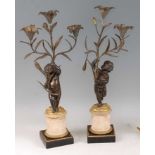 A pair of late 19th century French bronze and gilt bronze figural candelabra, the floral scroll