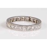 A white metal full hoop eternity ring, comprising twenty-four round brilliant cut diamonds in