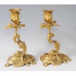 A pair of Rococo Revival gilt bronze Dolphinium candlesticks, each on swept bases and issuing twin