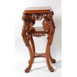 A contemporary carved walnut three-tier jardinière stand, having griffin mask swept supports, the