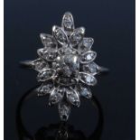 A white metal marquise shaped diamond cluster ring, featuring 19 round brilliant cut diamonds in