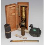 An early 20th century lacquered brass students monocular microscope, in fitted oak case with