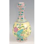 An early 20th century Chinese yellow and pink floral enamel decorated onion necked vase, having