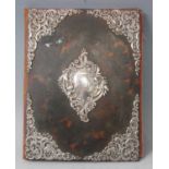 A late Victorian tortoiseshell and silver mounted desk blotter, with a red leather spine and back,
