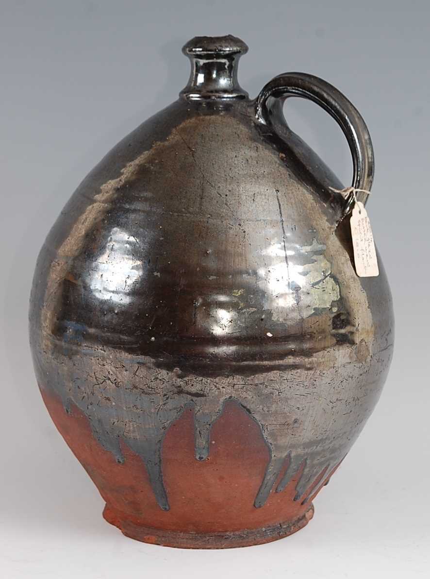 An early 19th century earthenware bellamine jug, of typical form, having silver lustre drip glaze,