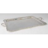 A George V silver twin handled drinks tray, of shaped rectangular form with raised edge, 31.7oz,
