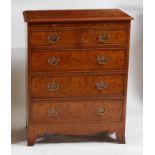 A walnut chest in the early 18th century style, having a rectangular moulded top with feather