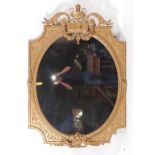 A Victorian giltwood and composition chimney mirror, of good size, the oval plate surmounted with