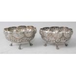 A pair of circa 1900 Indian white metal table salts, each of shaped and pierced oval form, decorated