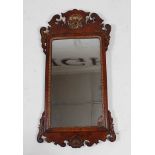 *An 18th century walnut and parcel gilt wall mirror, in the Chippendale style, having fret carved