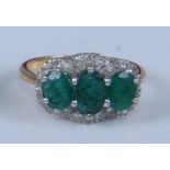 An 18ct yellow and white gold, emerald and diamond triple cluster ring, comprising three graduated
