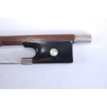 A late 19th century German violin bow, having nickel mounts and mother of pearl inlaid frog, 74cm,