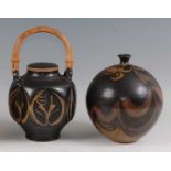 A studio pottery swing handle jar and cover, the cane handle over floral stylised decorated