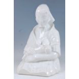 A large Continental Art Deco glazed pottery figure of a breast-feeding mother, wearing headscarf,