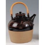 Beryl Debney - a large studio pottery hot water jug and cover, with integral cane swing handle,