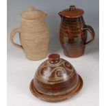A studio pottery Tenmoku glaze hot water jug and cover, of ribbed slender bulbous form, underglaze