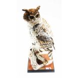 A modern Florence resin figure of an owl perched on a branch, on further base bearing label '