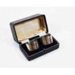 A cased pair of plain initialled silver napkin rings, 2.3oz, early 20th century