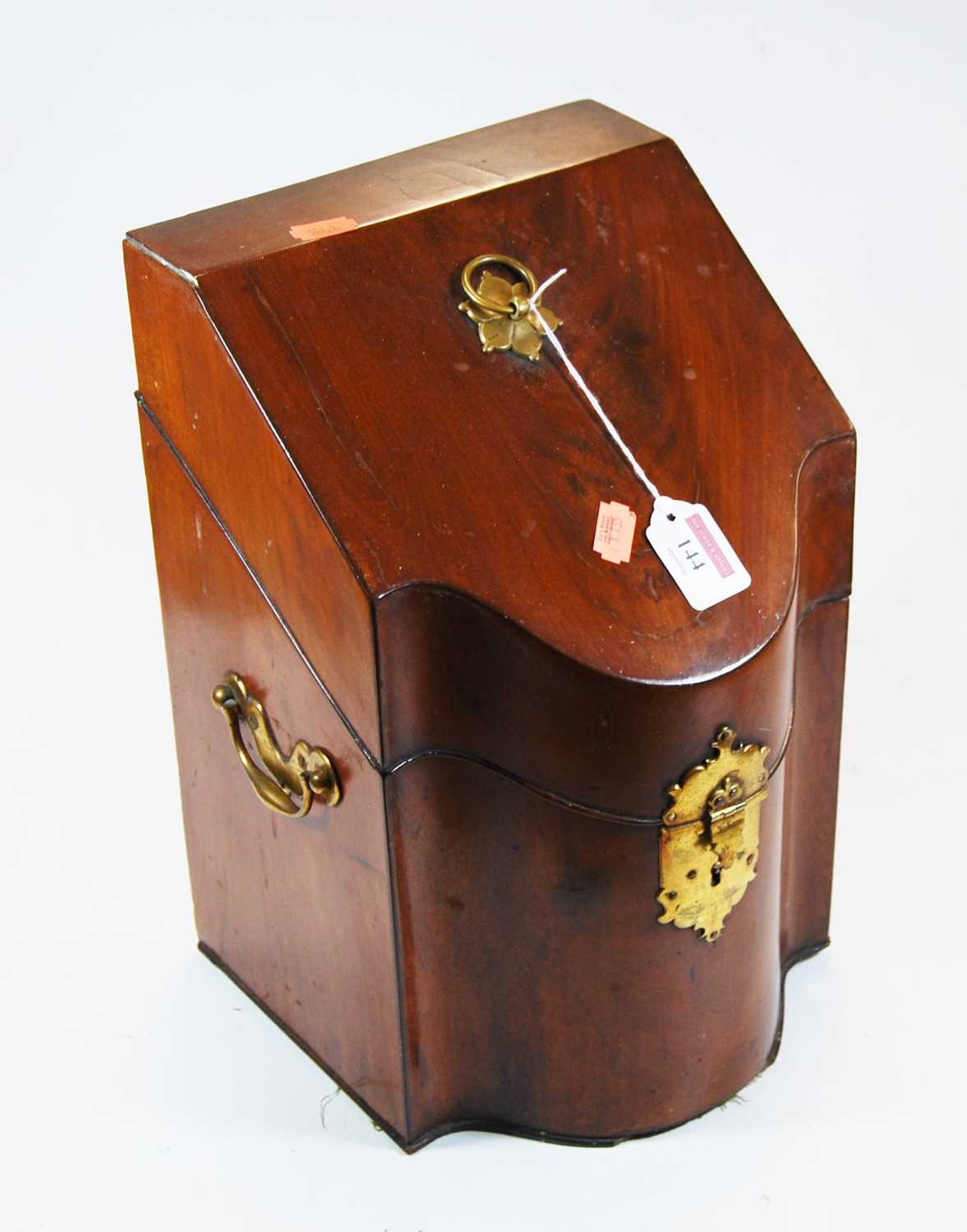 A George III mahogany knife box, of serpentine form, having brass loop handle and flanked by brass