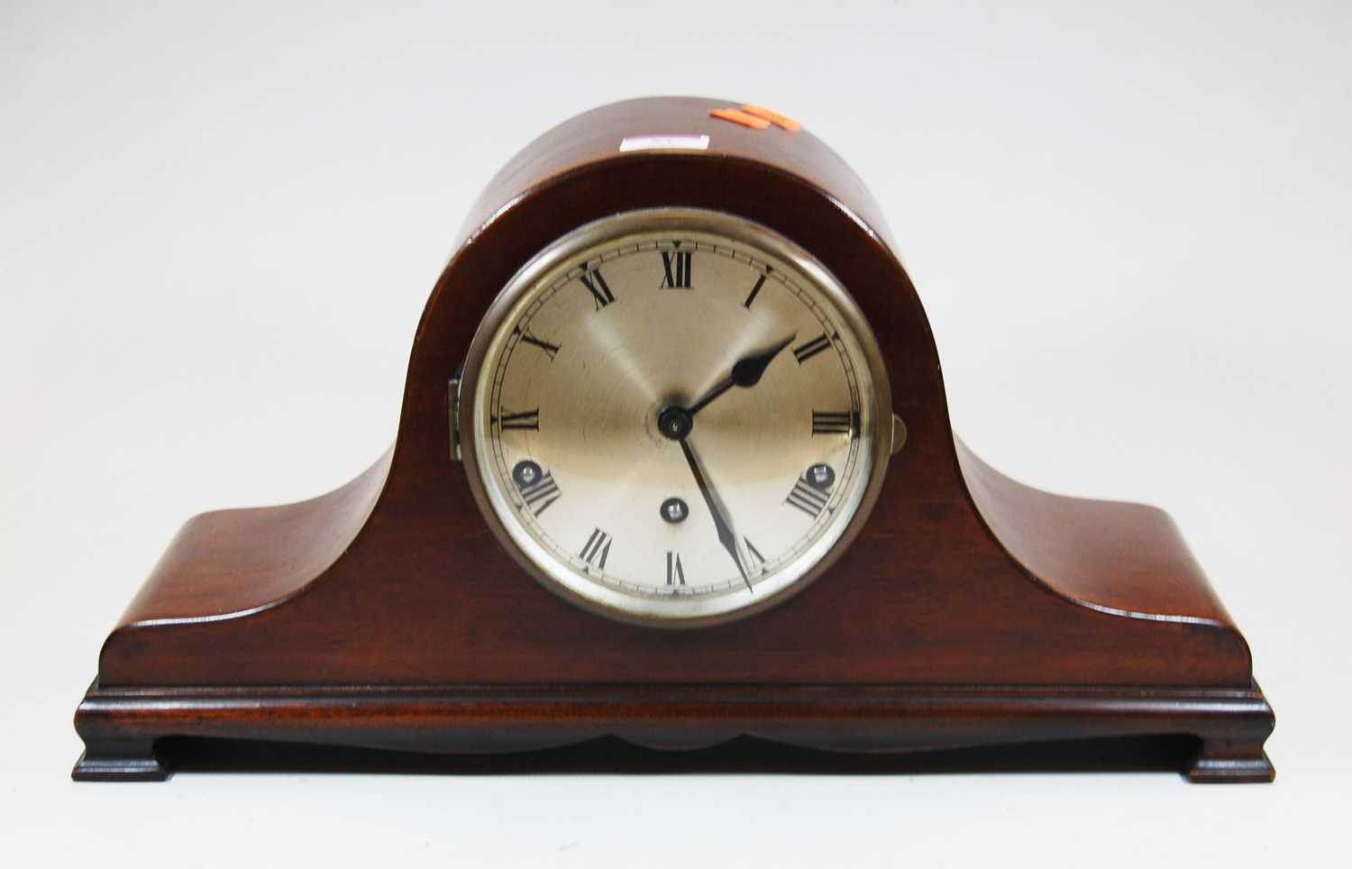An early 20th century mahogany cased mantel clock, the silvered dial showing Roman numerals,having
