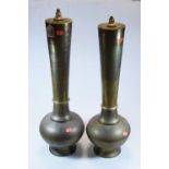 A pair of large Eastern brass table lamps, each having a tapered cylindrical neck to a bulbous lower