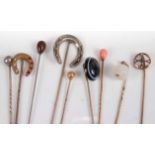 A collection of yellow metal and other tie-pins, to include coral topped example, agate example,