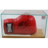 A Lonsdale boxing glove, as signed by Mike Tyson, in glazed box and with certificate of authenticity