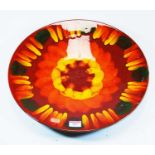 A Poole Pottery 'Volcano' pattern charger, decorated in shades of red, orange and yellow, having