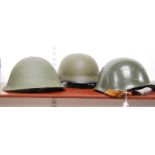 A post-WWII green painted turtle helmet; together with two others (3)