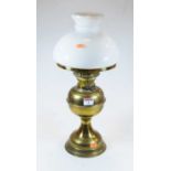An early 20th century glass oil lamp, the milk glass shade above a circular reservoir and foot, h.