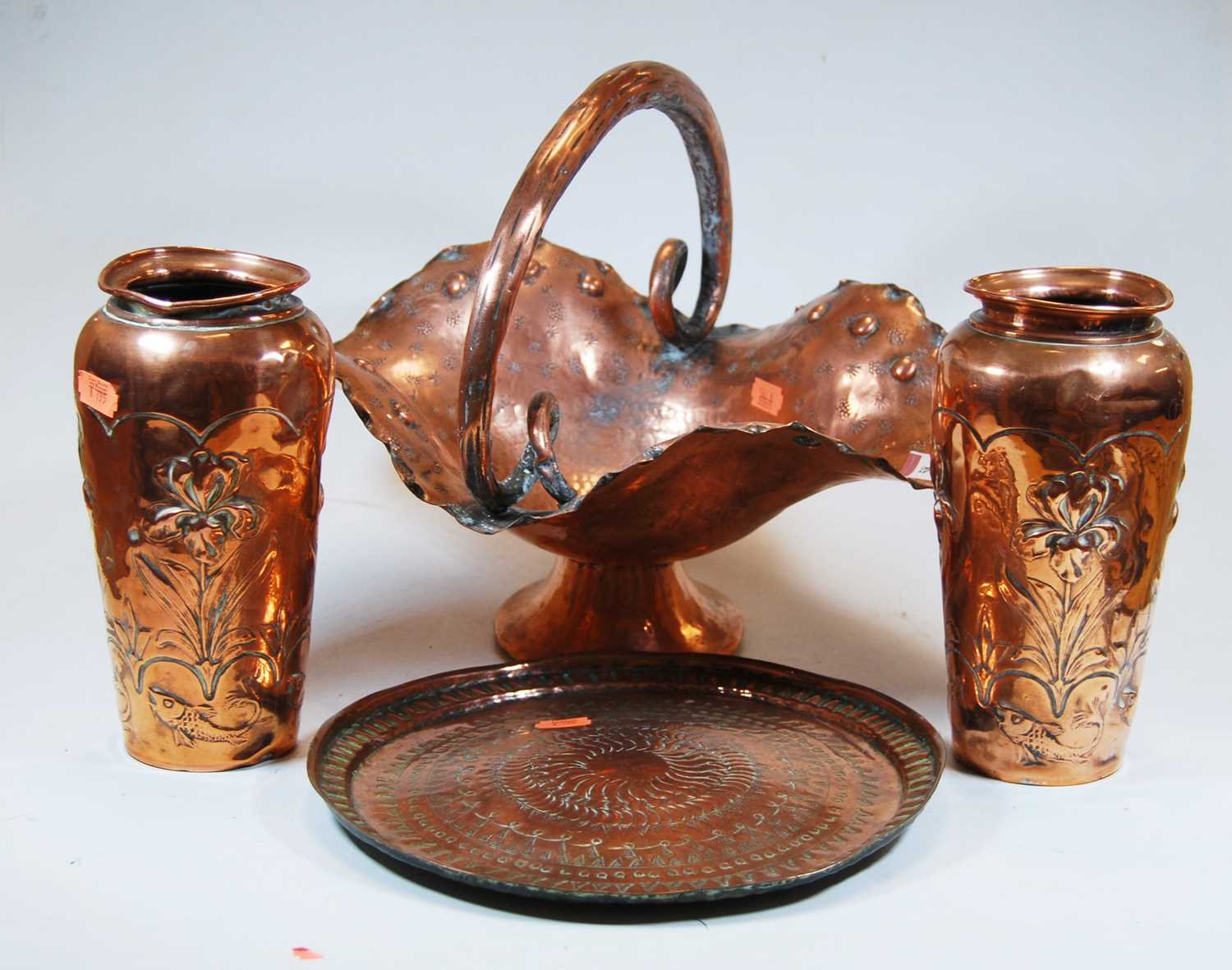 A pair of early 20th century copper vases, each relief decorated with flowers, h.21cm; together with