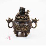 A Chinese bronzed metal koro and cover, the cover surmounted by a Fo dog above a pierced border, the