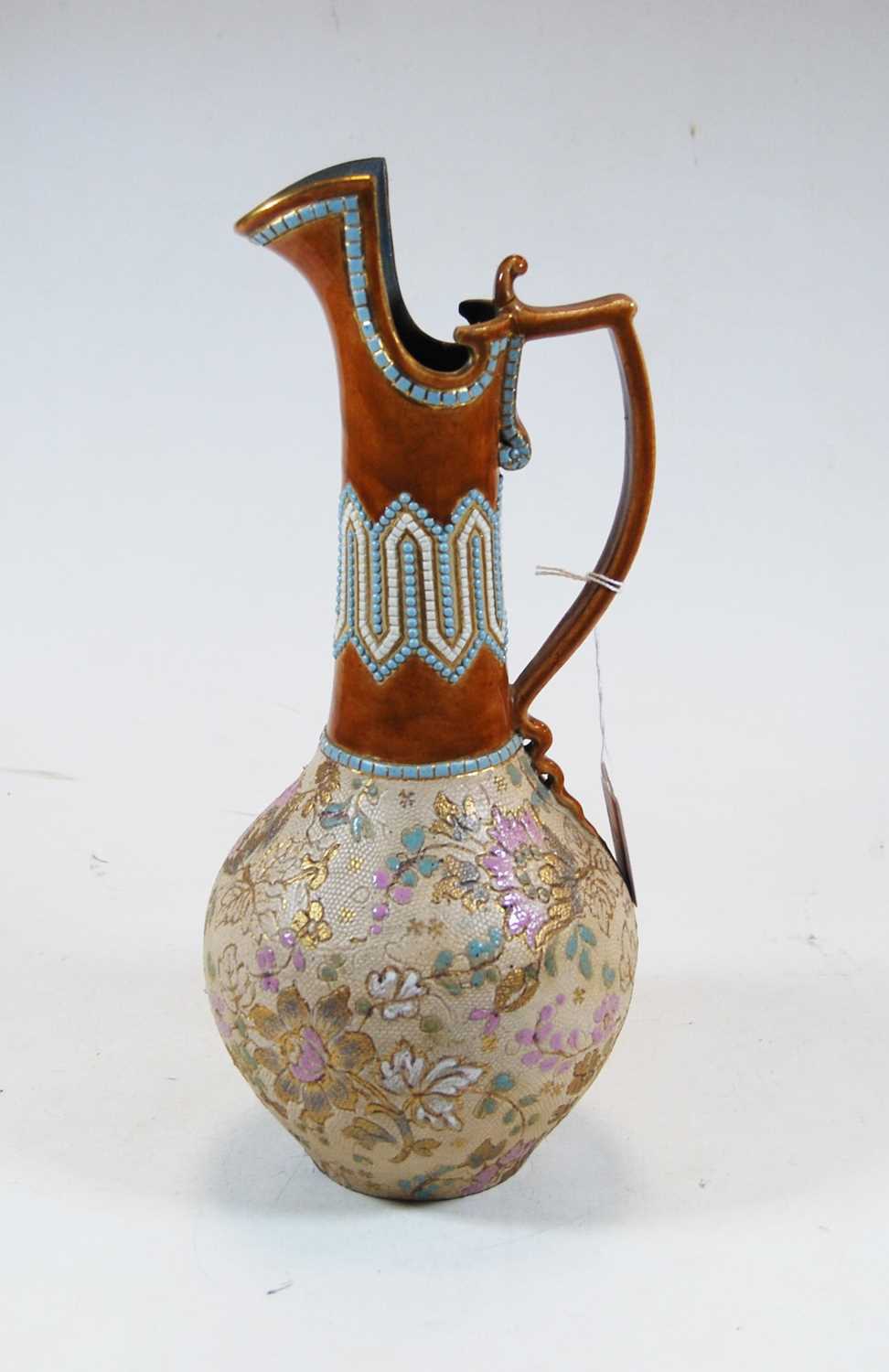 A Royal Doulton stoneware ewer, with beaded and floral decoration, h.31cm