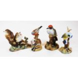 A Royal Crown Derby bone china woodpecker, with two others by Derby being thrush chicks and bluetit,