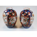 A pair of 19th century Chinese Imari vases, each of ovoid form with flaring rims, decorated with