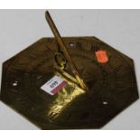 A brass sundial, the outer scale with Roman numerals, the inner scale with compass directions, dated