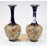 A pair of Royal Doulton stoneware bottle vases, the flared rims above a floral decorated body, h.