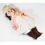 A 20th century German bisque headed doll, having opening eyes and lips parted to reveal a single