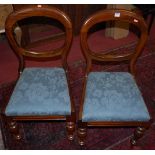A set of four Victorian mahogany balloon back dining chairs, having blue floral upholstered drop-